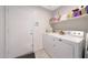 A bright laundry room with white appliances, storage, and shelving at 11207 W Turney Ave, Phoenix, AZ 85037