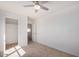 Carpeted bedroom with a ceiling fan, two doorways, and a closet at 11836 W Rosewood Dr, El Mirage, AZ 85335