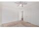 A bright carpeted bedroom with a ceiling fan and open doorway at 11836 W Rosewood Dr, El Mirage, AZ 85335