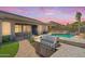 An outdoor kitchen and grill next to the refreshing pool with its rock waterfall feature at 11958 W Villa Chula Ln, Sun City, AZ 85373