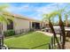Expansive backyard featuring lush green grass and mature palm trees, enclosed by black metal fencing at 11958 W Villa Chula Ln, Sun City, AZ 85373