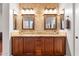 Elegant bathroom featuring double sinks, granite countertops, and decorative mirrors at 11958 W Villa Chula Ln, Sun City, AZ 85373
