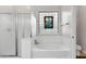 Bathroom featuring soaking tub with glass door and a stained glass window at 11958 W Villa Chula Ln, Sun City, AZ 85373