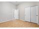Bedroom with wood floors, bi-fold closet doors, and an open doorway to another room at 11958 W Villa Chula Ln, Sun City, AZ 85373