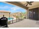 Inviting covered patio view of the outdoor kitchen, fenced pool, and lush landscaping for ultimate backyard retreat at 11958 W Villa Chula Ln, Sun City, AZ 85373