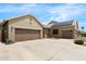 A clean three-car garage with a wide driveway and drought-tolerant desert landscaping at 11958 W Villa Chula Ln, Sun City, AZ 85373