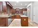 Beautiful kitchen featuring stainless steel appliances, rich wood cabinets, and a center island at 11958 W Villa Chula Ln, Sun City, AZ 85373