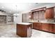 Stylish kitchen featuring custom wood cabinets, a center island, and neutral tile flooring at 11958 W Villa Chula Ln, Sun City, AZ 85373
