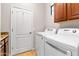 A laundry room with modern washer and dryer, tile floors, and access to storage at 11958 W Villa Chula Ln, Sun City, AZ 85373