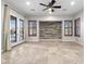 Open living room with tile floors, French doors, wood accent wall, and custom window shutters at 11958 W Villa Chula Ln, Sun City, AZ 85373