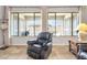 Inviting living room featuring travertine tile, comfortable seating, and beautiful views of the outdoor space at 11958 W Villa Chula Ln, Sun City, AZ 85373