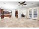 Spacious living area with tile flooring, wooden accents, open access to kitchen, and access to an outdoor patio at 11958 W Villa Chula Ln, Sun City, AZ 85373