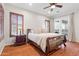 Spacious main bedroom featuring wood floors, ceiling fan, and access to balcony at 11958 W Villa Chula Ln, Sun City, AZ 85373