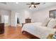 Spacious main bedroom featuring wood floors, ceiling fan, and access to other rooms at 11958 W Villa Chula Ln, Sun City, AZ 85373