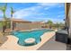 Refreshing backyard pool features a waterfall, in-water seating, and an outdoor kitchen perfect for entertaining at 11958 W Villa Chula Ln, Sun City, AZ 85373