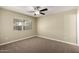 Cozy bedroom with a window dressed with blinds and plush carpeting at 13439 W Desert Ln, Surprise, AZ 85374