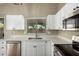 Bright kitchen featuring stainless steel appliances, white cabinetry, and a window at 13439 W Desert Ln, Surprise, AZ 85374