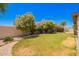 Lush backyard featuring manicured lawn, stone-lined flowerbeds, and a variety of flowering plants at 13824 N 148Th Ln, Surprise, AZ 85379