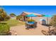 Inviting backyard with patio dining set, lush landscaping, and covered porch at 13824 N 148Th Ln, Surprise, AZ 85379