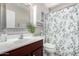 Well-lit bathroom with vanity, mirrored cabinet, and shower with green-patterned curtain at 13824 N 148Th Ln, Surprise, AZ 85379