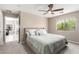 Well-lit bedroom with view of the backyard, ceiling fan, and neutral carpet at 13824 N 148Th Ln, Surprise, AZ 85379