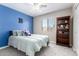 Charming bedroom featuring blue accent wall, ceiling fan, and well-organized bookshelf at 13824 N 148Th Ln, Surprise, AZ 85379