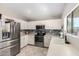 Well-lit kitchen features stainless steel appliances, white cabinets, and a modern sink at 13824 N 148Th Ln, Surprise, AZ 85379