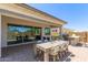 Covered outdoor patio with outdoor dining set, built-in grill and ample seating area at 14116 W Honeysuckle Dr, Surprise, AZ 85387
