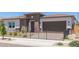 Inviting single-story home featuring desert landscaping, a sleek black fence, and a charming facade at 14116 W Honeysuckle Dr, Surprise, AZ 85387