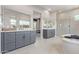A modern main bathroom with dual vanities, tile floors, and a freestanding soaking tub at 14116 W Honeysuckle Dr, Surprise, AZ 85387