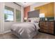 Modern bedroom with bright accent wall, providing an energetic space with natural lighting at 14124 W Honeysuckle Dr, Surprise, AZ 85387
