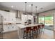 Modern kitchen with white cabinets, stainless steel appliances, and large island with seating at 14124 W Honeysuckle Dr, Surprise, AZ 85387