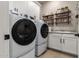 Modern laundry room featuring appliances, sink, and shelving for organization at 14124 W Honeysuckle Dr, Surprise, AZ 85387