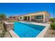 Backyard view of the luxurious pool with water feature and lush landscape on a sunny day at 14124 W Honeysuckle Dr, Surprise, AZ 85387