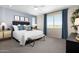 Serene bedroom with plush carpeting, an accent wall, large windows, and stylish decor creating a relaxing retreat at 15159 W Gray Fox Trl, Surprise, AZ 85387