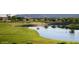 Picturesque golf course view with lush green fairways and a serene pond, set against a backdrop of distant mountains at 15159 W Gray Fox Trl, Surprise, AZ 85387