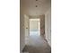 Hallway with white walls, a staircase with wood railings, and doorway that opens to a bright room at 15159 W Gray Fox Trl, Surprise, AZ 85387
