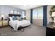Cozy main bedroom features a large window with natural light, a comfortable bed, and stylish decor at 15159 W Gray Fox Trl, Surprise, AZ 85387
