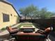 The backyard has a rectangular artificial turf, desert landscaping, and a fire pit with outdoor seating at 1526 E Hazel Dr, Phoenix, AZ 85042
