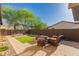 Inviting backyard with synthetic grass, desert landscaping, and a cozy seating area with a fire pit at 1526 E Hazel Dr, Phoenix, AZ 85042