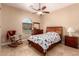 Cozy bedroom features a ceiling fan, wood furniture and a sunny window at 1526 E Hazel Dr, Phoenix, AZ 85042