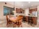 Dining room featuring travertine floors with kitchen view and custom-built cabinets at 1526 E Hazel Dr, Phoenix, AZ 85042
