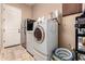 This laundry room features a washer, dryer, refrigerator, storage and utility sink at 1526 E Hazel Dr, Phoenix, AZ 85042