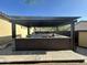 This outdoor kitchen features a built-in grill, counter space, mini fridge, and a pergola with lighting at 1526 E Hazel Dr, Phoenix, AZ 85042