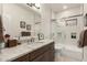 Bathroom vanity with stone countertop and a combined shower and bathtub with sliding glass doors at 18021 N 53Rd St, Scottsdale, AZ 85254