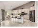 Open kitchen with an island and seating, featuring white cabinets, modern appliances, and a connecting breakfast nook at 18021 N 53Rd St, Scottsdale, AZ 85254