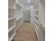 Walk-in closet boasts custom shelving and wooden hanging rods at 18035 E San Tan Blvd, Queen Creek, AZ 85142