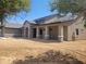 New home features a covered entry, brick accents, dark roof, and stucco exterior at 18035 E San Tan Blvd, Queen Creek, AZ 85142