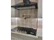 Modern kitchen features a stainless steel cooktop, pot filler, decorative backsplash, and white cabinets at 18035 E San Tan Blvd, Queen Creek, AZ 85142