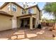 Exterior shot of the home's backyard with a covered patio, stone pathway, gravel landscaping, and privacy fence at 1835 S Rockwell St, Gilbert, AZ 85295